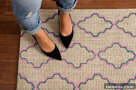 A stylish woman standing on a tan carpet with a chic blue and pink design outlined on it.