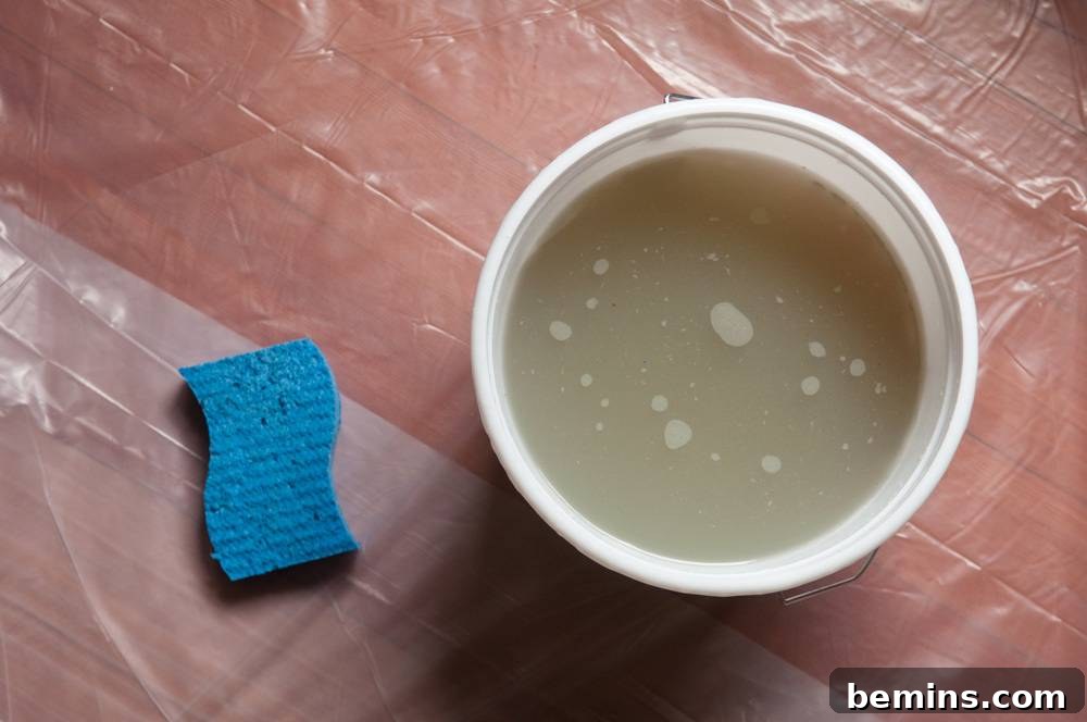 Cleaning a wood floor with a sponge and bucket.