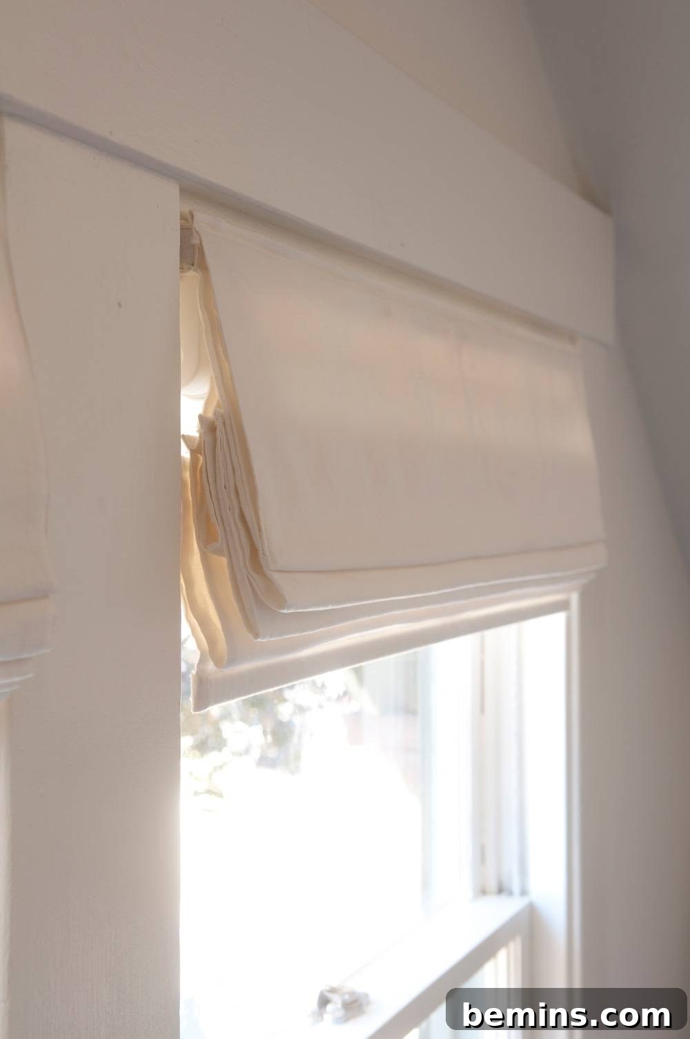 A white window with Signature Roman Shades from Blinds.com.