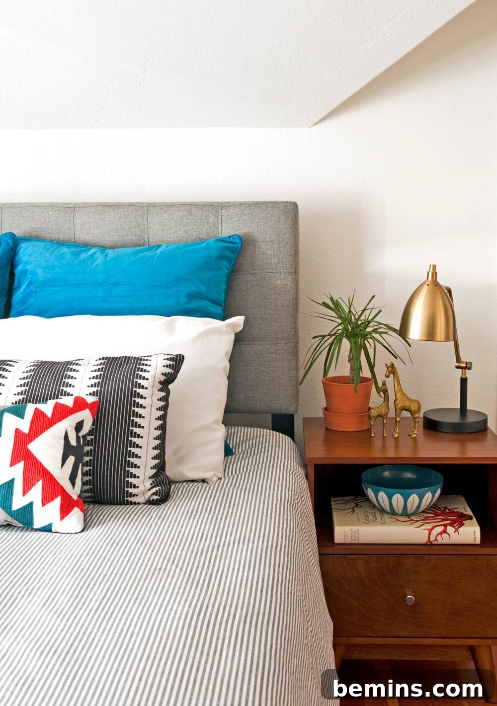 Bedroom along with bed, bed sheet, pillows and table.