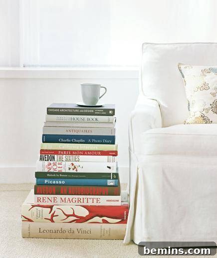 A stack of colorful books next to a white chair