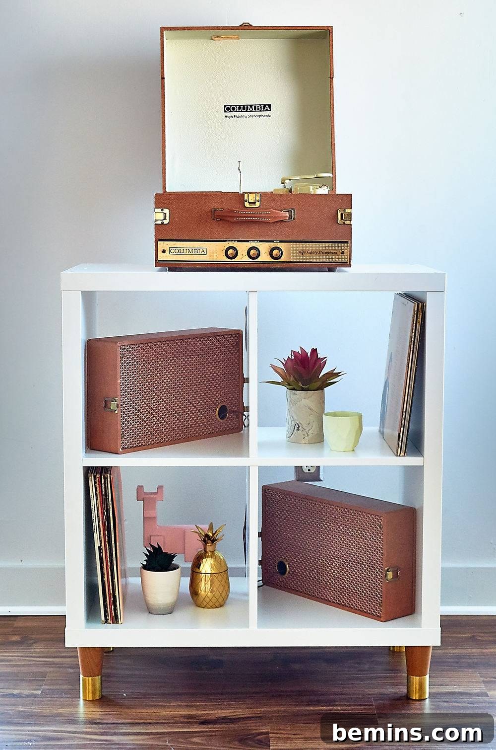 An old-fashioned Columbia record player sitting atop a small side table with speakers on the shelves below.