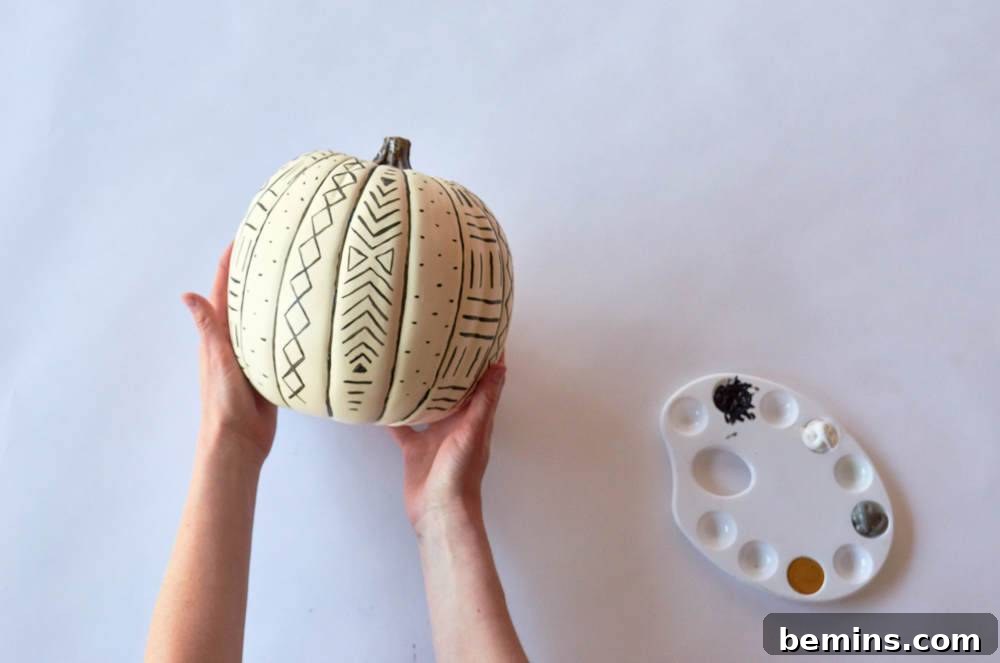 Pumpkin is decorated with different designs and colors.