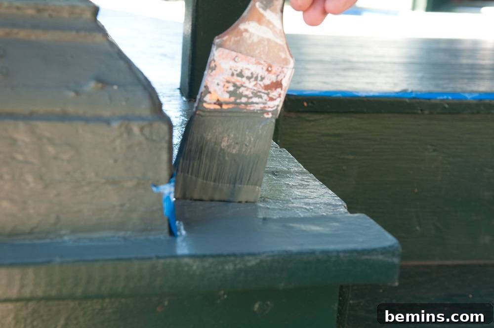 Painting stairs with a blue-colored paintbrush.
