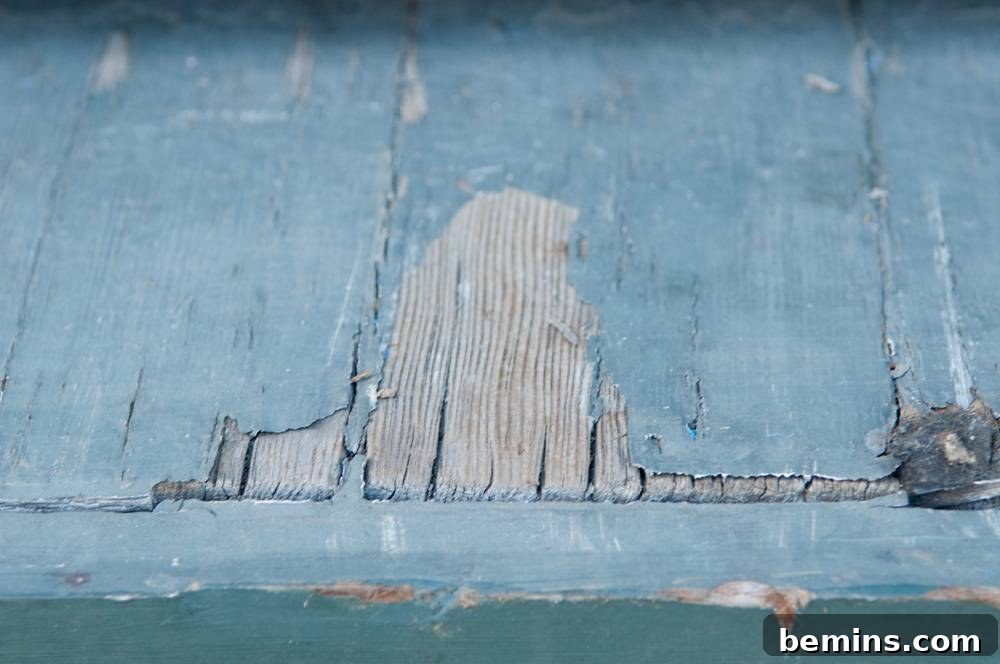Chipped and weathered bluish-gray wooden slats on a porch floor.