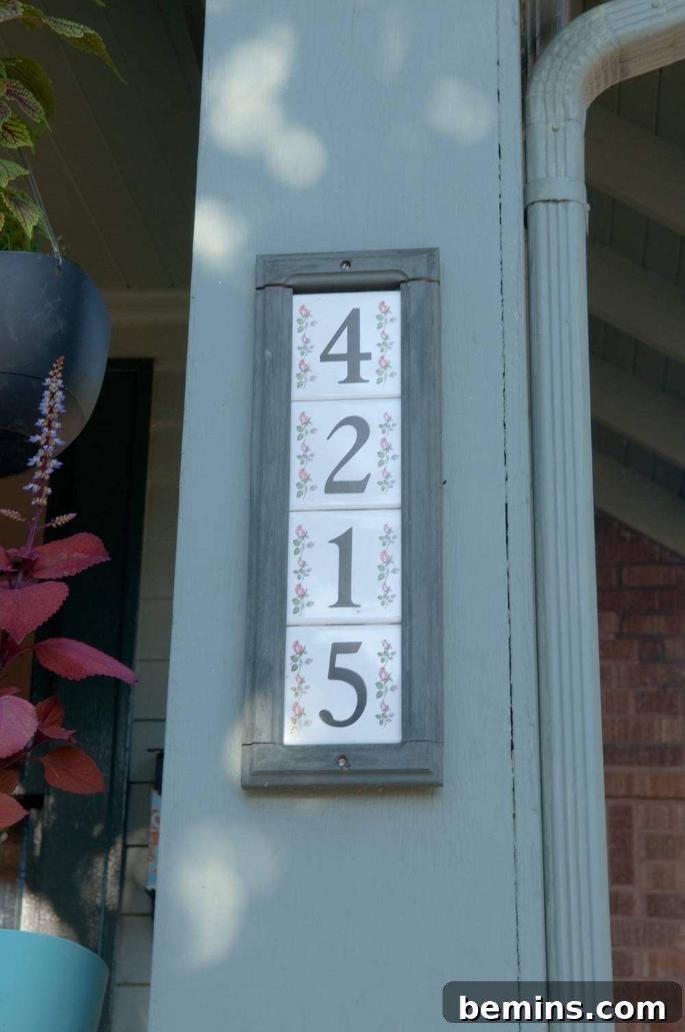 Decorative tiles with numbers by the front door, featuring a floral design.